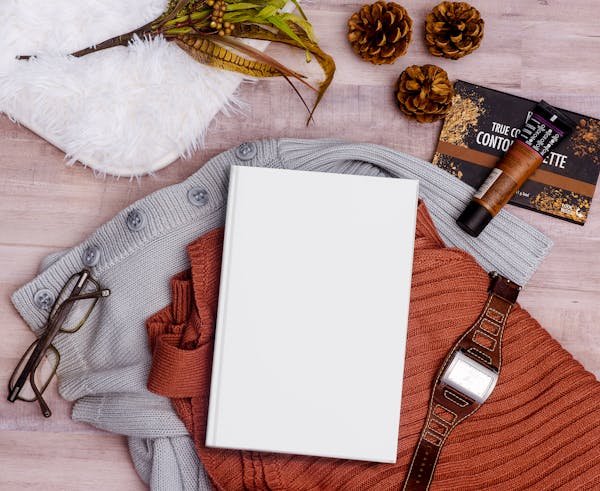 Elegant flat lay featuring a book, clothing, and accessories perfect for autumn inspiration.