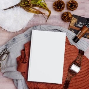 Elegant flat lay featuring a book, clothing, and accessories perfect for autumn inspiration.